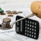 soziale Absicherung für Solopreneure - Löffel als Waage mit Geld und Kartoffel balanciert auf einem Taschenrechner