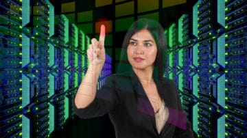 Woman using touch screen interface in modern data center